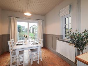 a dining room with a table with chairs and a window at Little Launde Cottage in Leicester