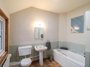 a bathroom with a sink and a toilet and a bath tub at Little Launde Cottage in Leicester +16 photos