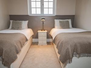 two twin beds in a room with a window at Little Launde Cottage in Leicester