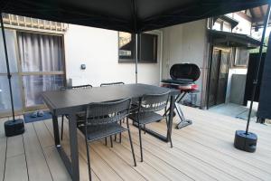 a black table and chairs on a deck with an umbrella at 侘然 - Wabizen - in Ikeda