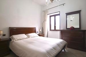 a bedroom with a white bed with a dresser and a window at Free Parking - Maria House in Torre del Greco