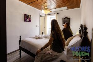 two women sitting on a bed in a bedroom at Sunset Pool House in Feteira +19 photos