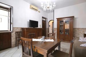 a living room with a wooden table and a television at Free Parking - Maria House in Torre del Greco