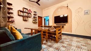 a living room with a table and a tv at GoArize by Rootsvilla Vagator in Anjuna