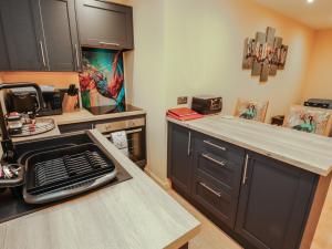 a kitchen with black cabinets and a counter top at The Nook in Wigton