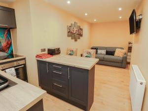 a kitchen with a counter top and a living room at The Nook in Wigton +14 photos