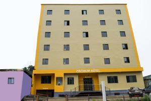 ein hohes gelbes Gebäude mit einem Hotelschild darauf in der Unterkunft Premium HOTEL in Douala