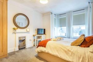a bedroom with a bed with a fireplace and a mirror at 4 Bed in St. Austell oc-t32965 in St Austell