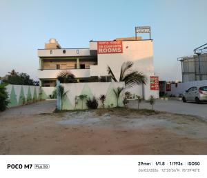a building with palm trees in front of it at Hotel ZB comforts MYSORE in Mysore