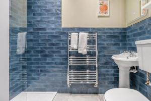a blue tiled bathroom with a toilet and a sink at 5 Bed in Llangollen oc-l34205 in Llangollen +46 photos