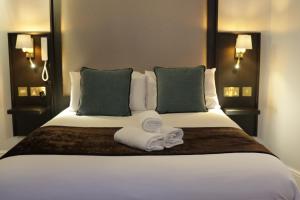 a bedroom with a bed with two towels on it at Arran House Hotel in London