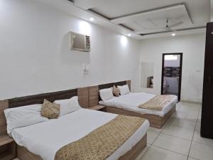 a room with two beds and a mirror at Prem Resort in Vrindāvan