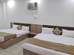 a room with two beds and a air conditioner at Prem Resort in Vrindāvan