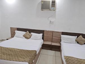 a room with two beds and a air conditioner at Prem Resort in Vrindāvan