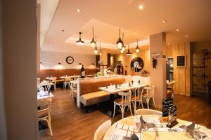 a restaurant with tables and chairs in a room at Hotel Le Richelieu in Le Tréport +23 photos