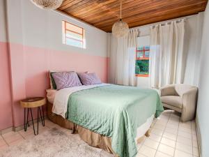 a bedroom with a bed and a chair at Casarão in Marechal Floriano +9 photos