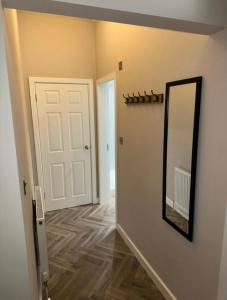 a hallway with a mirror and a white door at HORSEMARKET on the square in Kelso