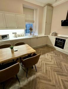 a kitchen with a wooden table and chairs and a wooden floor at HORSEMARKET on the square in Kelso