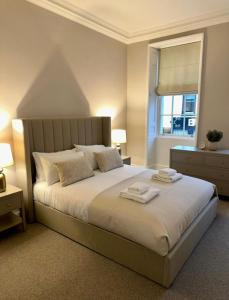 a bedroom with a large bed with two towels on it at HORSEMARKET on the square in Kelso
