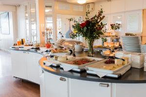 a kitchen with many plates of food on a counter at Hotell och Restaurang Hovs Hallar in Båstad