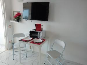a room with a table with a microwave and chairs at Ponderosa Holiday Studio 701 in Playa de las Americas