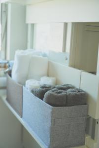 a pile of towels in a box in front of a mirror at Aioi house in Tsubetsu