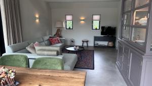 a living room with a couch and a tv at Erve t Hoolterhof in Holten