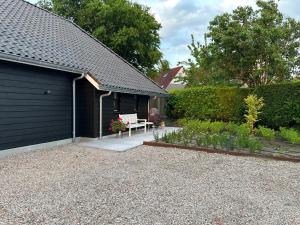 a garage with a bench in a garden at Erve t Hoolterhof in Holten