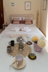 a table with cups and plates on top of a bed at Stergios_Apartments 05 in Kozani