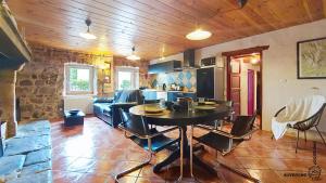 a kitchen and living room with a table and a couch at La Ferrandaise in Chambon-sur-Lac