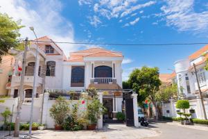 a white house with a gate in a street at Villa 25 Lạc Long Quân in Vung Tau