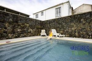 a woman in a yellow dress is standing in a swimming pool at Sunset Pool House T2 in Feteira