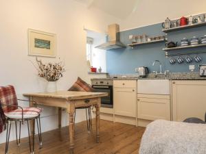 a kitchen with a wooden table and a counter top at The Old Studio in Penzance