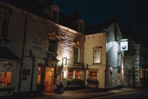 an old building with lights on it at night at The Black Swan Inn in Pickering