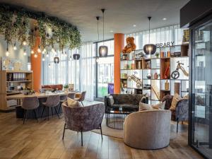 a living room with chairs and a table and a room at Adagio Access Stuttgart Airport Messe in Leinfelden-Echterdingen