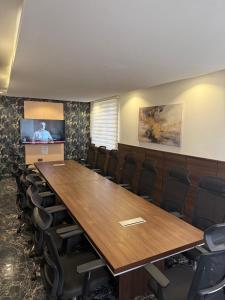 a conference room with a large wooden table and chairs at SAAFI Boutique Hotel in Abuja
