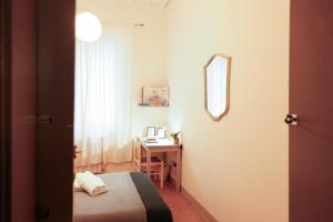 a bedroom with a bed and a desk with a mirror at Casa Pepe in Pisa