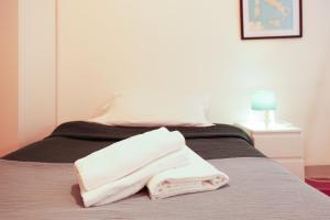 a pile of towels sitting on a bed at Casa Pepe in Pisa