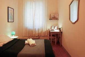 a bedroom with a bed and a desk and a window at Casa Pepe in Pisa