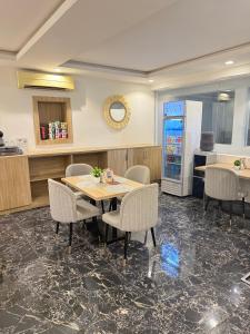 a restaurant with a table and chairs and a refrigerator at SAAFI Boutique Hotel in Abuja