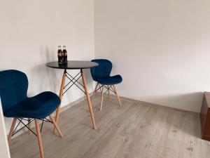 two blue chairs and a table with drinks on it at Silesia młyn in Katowice