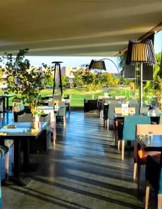 a restaurant with tables and chairs and a view at Cozy Golf Apartment Wifi 4k-TV Netflix in Marrakesh