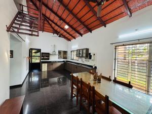 a large kitchen with a wooden table and chairs at Rego Farms in Mangalore