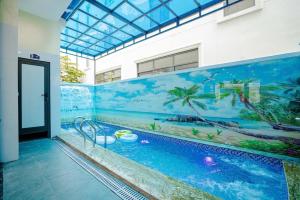 a swimming pool with a mural on the side of a building at Hotel Hải Âu in Sầm Sơn
