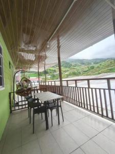 a table and chairs on a balcony with a view at Kundasang height valley in Ranau