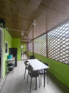 a table and chairs in a room with green walls at Kundasang height valley in Ranau