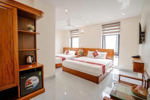 a hotel room with two beds and a television at Hotel Hải Âu in Sầm Sơn +19 photos