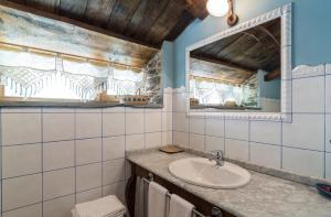 a bathroom with a sink and a mirror at O Muiño de Pena in O Pino  +101 photos