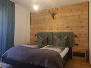 a bedroom with a large bed with a wooden wall at B&B Brunnerhof in Feldthurns
