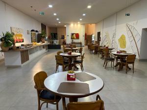 a restaurant with tables and chairs and a counter at Hotel Oscar Gold Janaúba in Janaúba